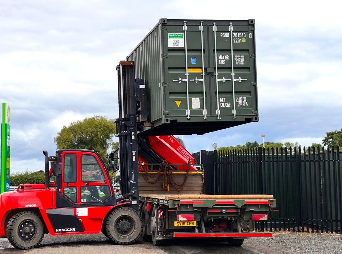 A forklift moving a shipping container at the depot on the A66